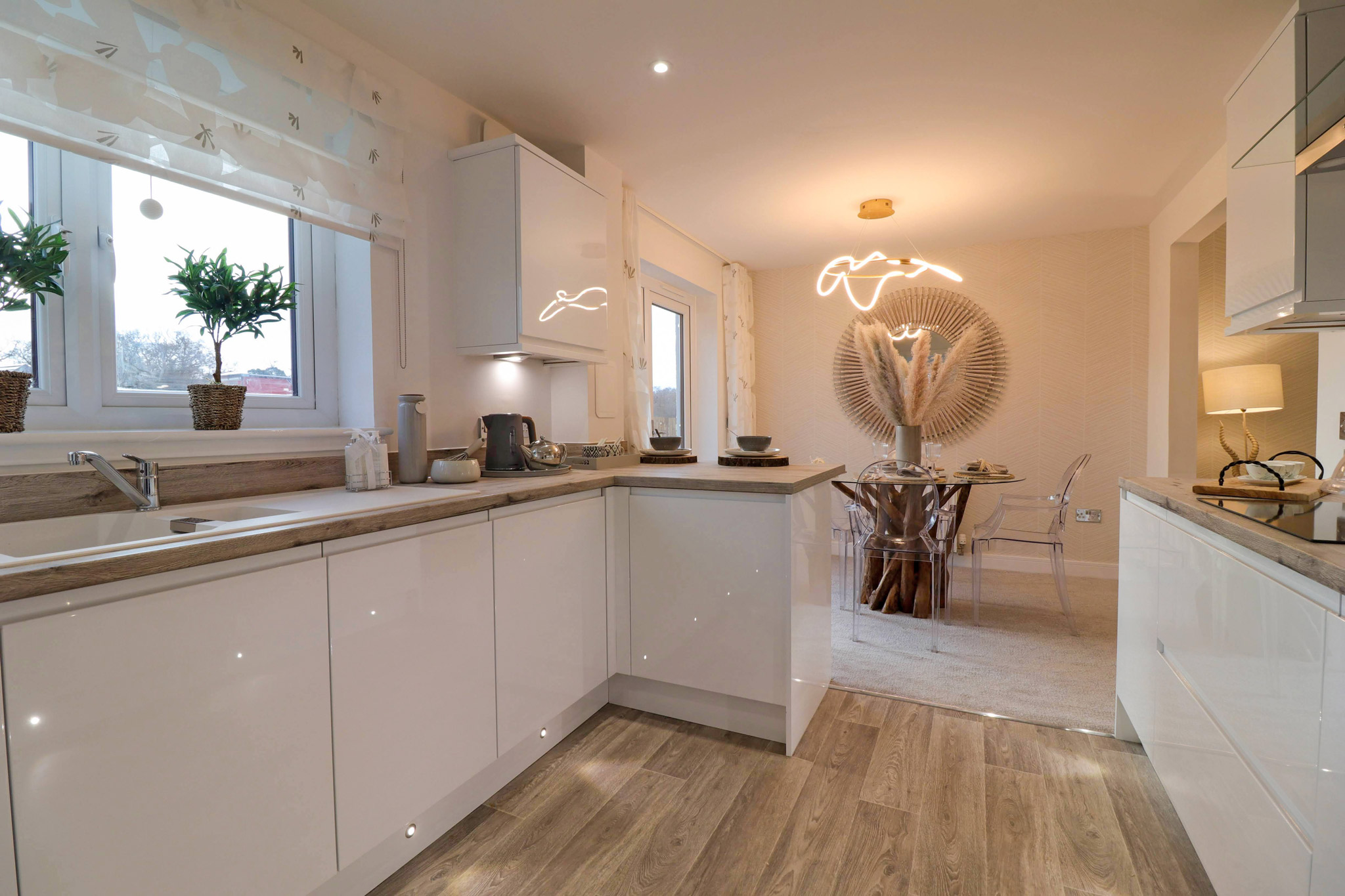 Sparkling white Spey Showhome kitchen looking onto stylish dining table and chairs